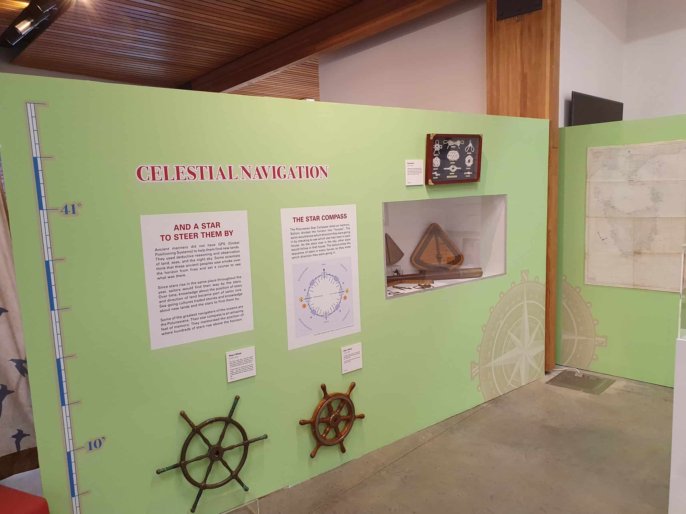 Image of a wall in the exhibition. Wall is light green with interpretive text and objects.